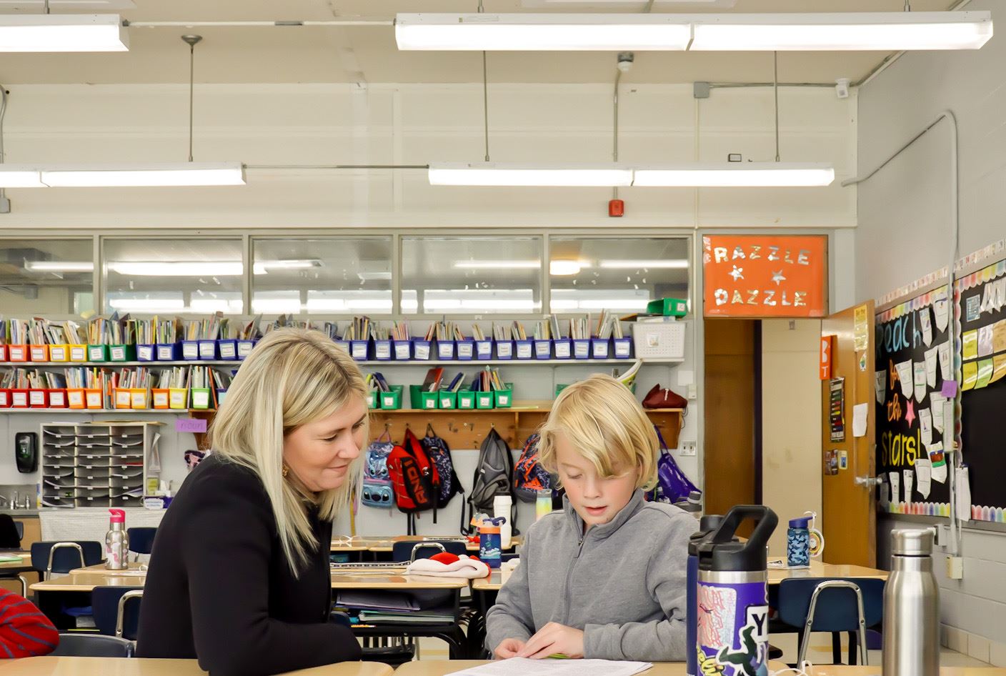  Assistatn Principal Kate Altman reads along with a student during a publishing party